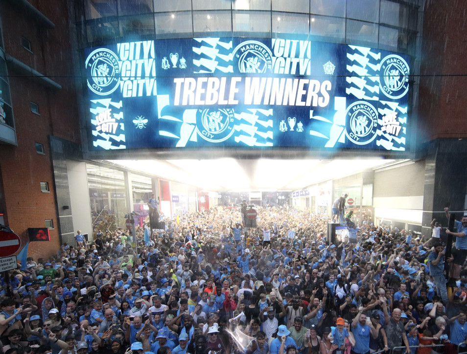 Crowd celebrating City's treble win.