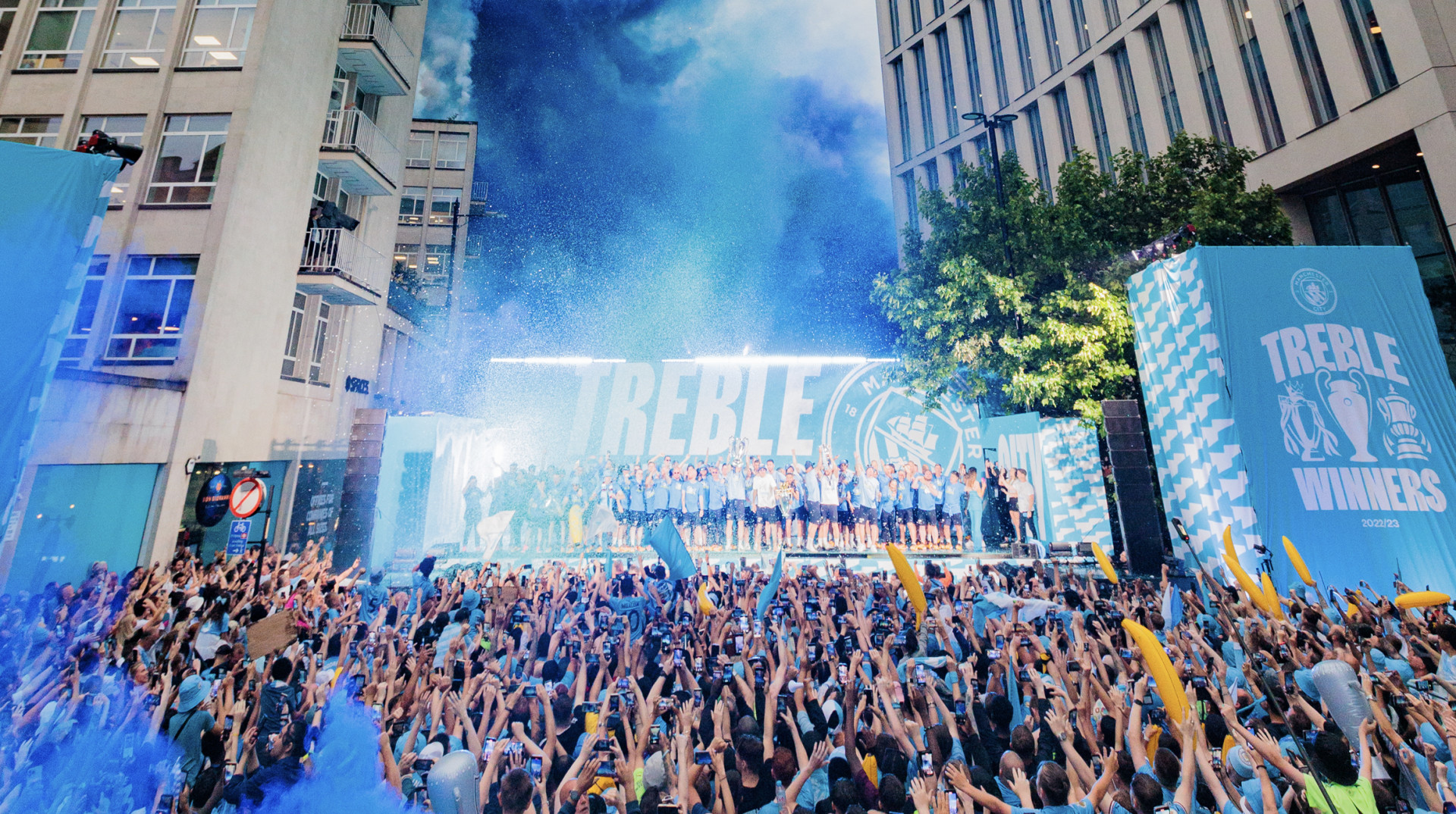 Crowd celebrating City's treble win